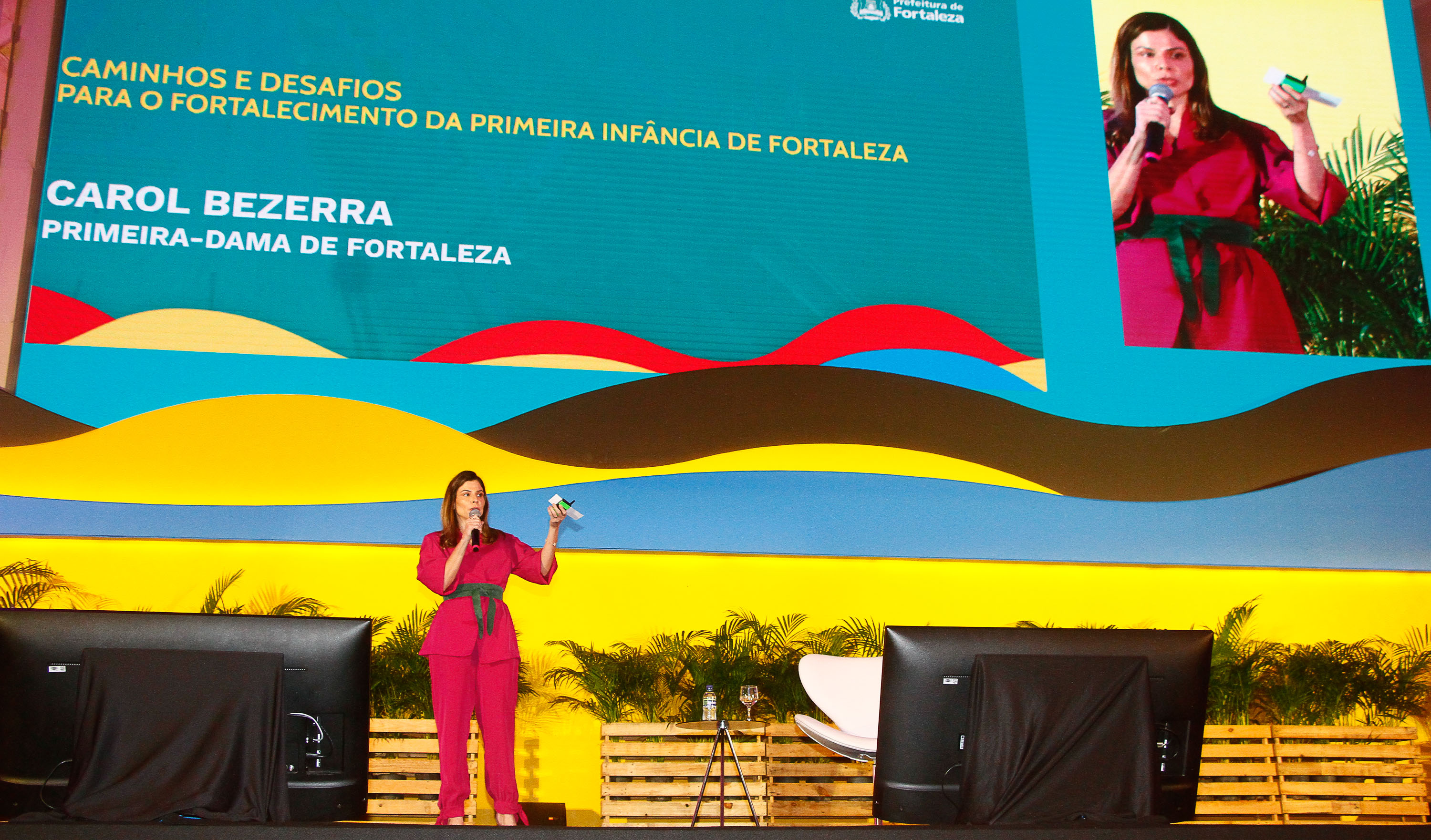 primeira-dama carol bezerra fala ao microfone em um palco